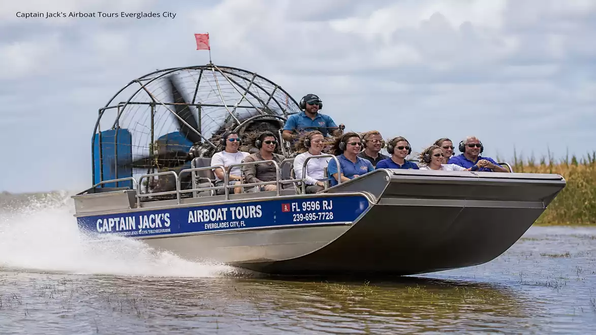 A group of people enjoys an airboat tour through the Everglades with Captain Jack's Airboat Tours on a sunny day.