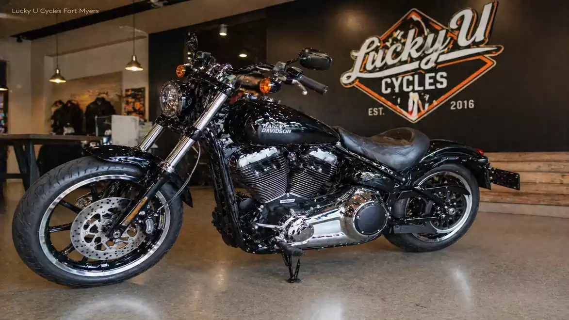 Black motorcycle inside a showroom of Lucky U Cycles, featuring polished metal elements and leather details.