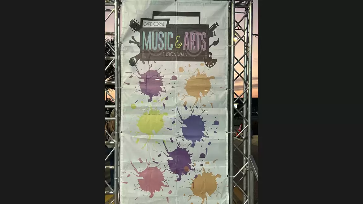 Advertisement poster for a music and arts festival with various paint splatters on a white background.