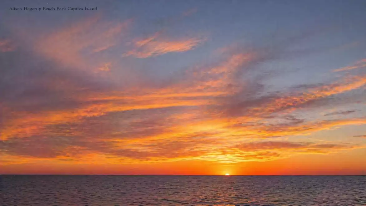 A breathtaking sunset over the sea with a sky full of vibrant orange and blue hues.