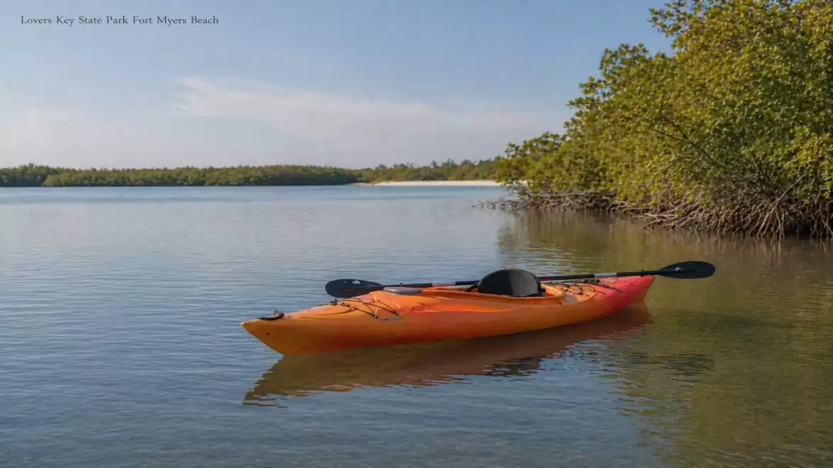 A red kayak floats on calm waters in a picturesque river landscape, surrounded by green nature and blue skies.