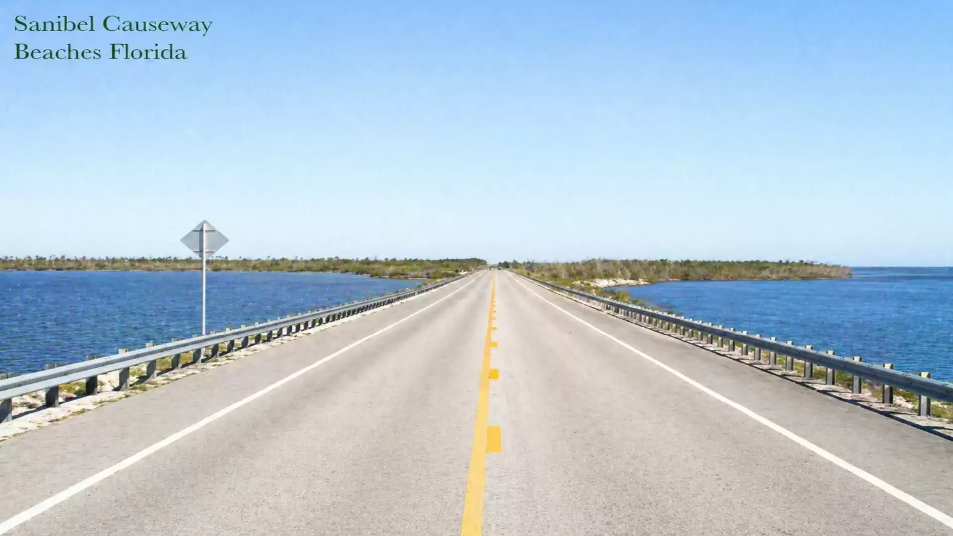 Sanibel Causeway in Florida, a paved road stretching over the sea with a blue sky in the background.