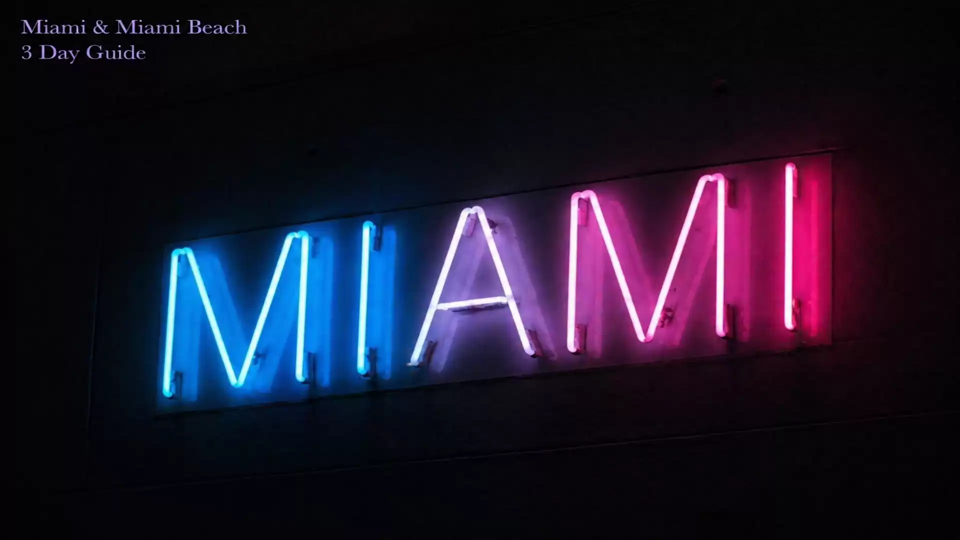 Neon sign with the word 'Miami' in blue and pink letters on a black background.