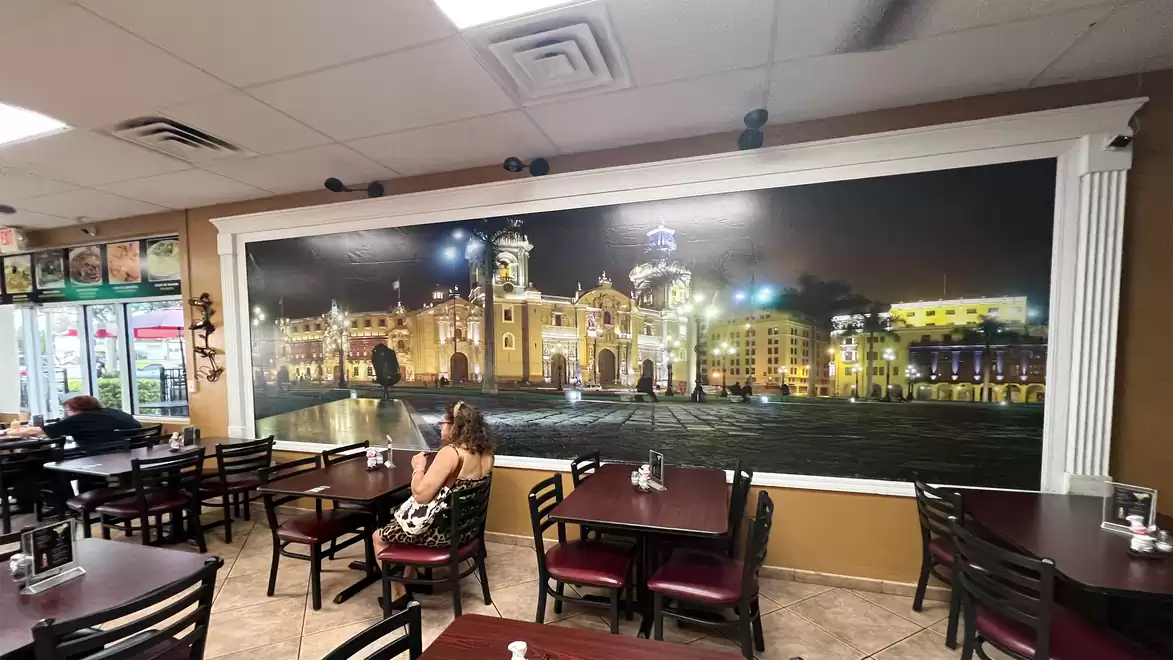 A restaurant with a large wall mural depicting a lit cityscape.