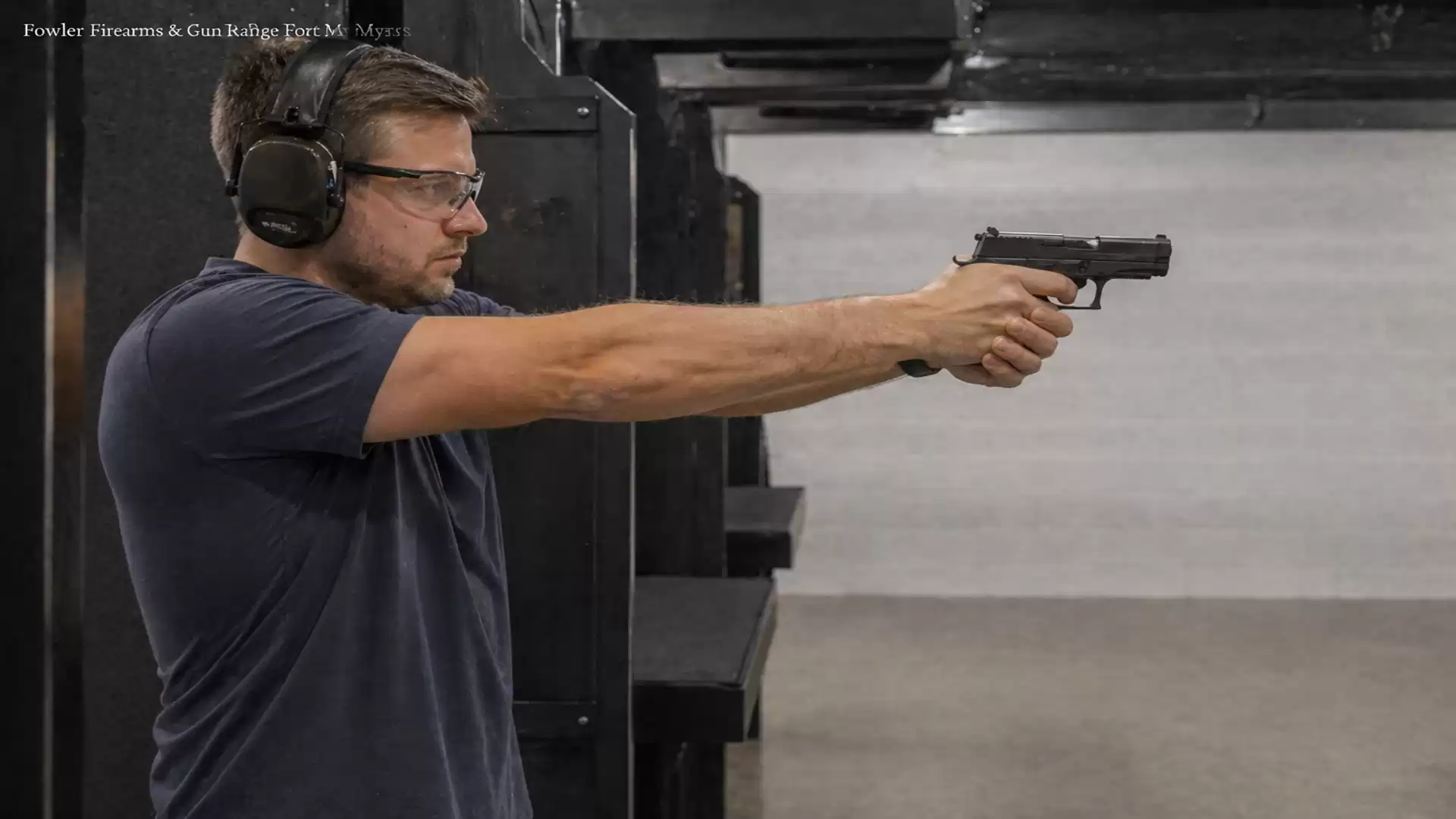 Man aiming with a pistol at a shooting range.
