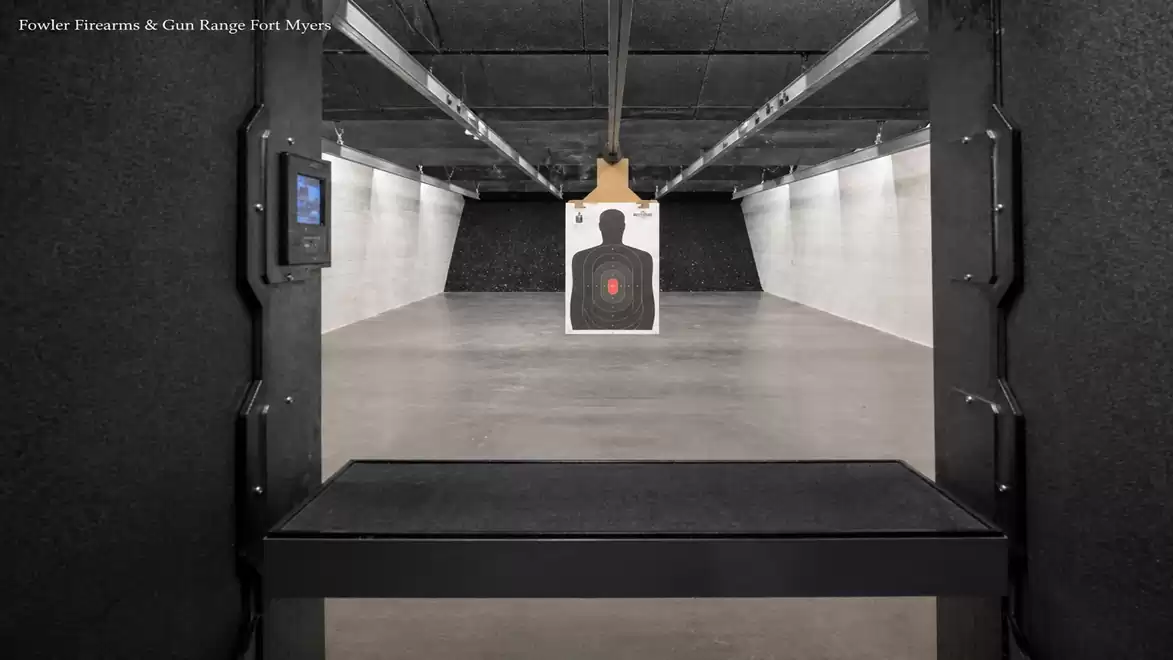 A shooting range with a target in a lit room.
