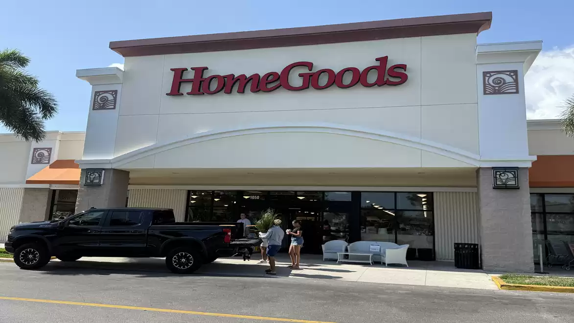 Exterior view of a HomeGoods store with a black pickup truck and people in front.