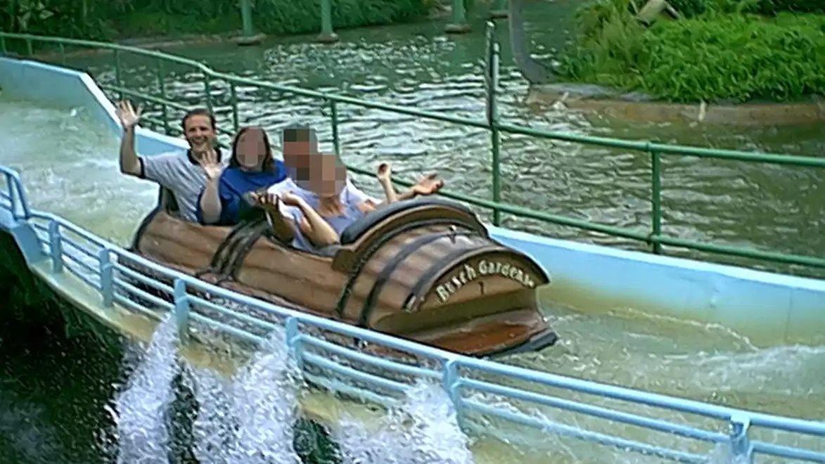 People riding a log flume in an amusement park.