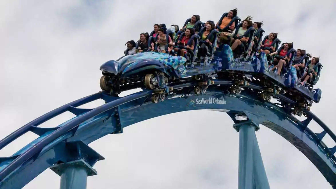 People on a roller coaster enjoying the thrill of a steep descent.