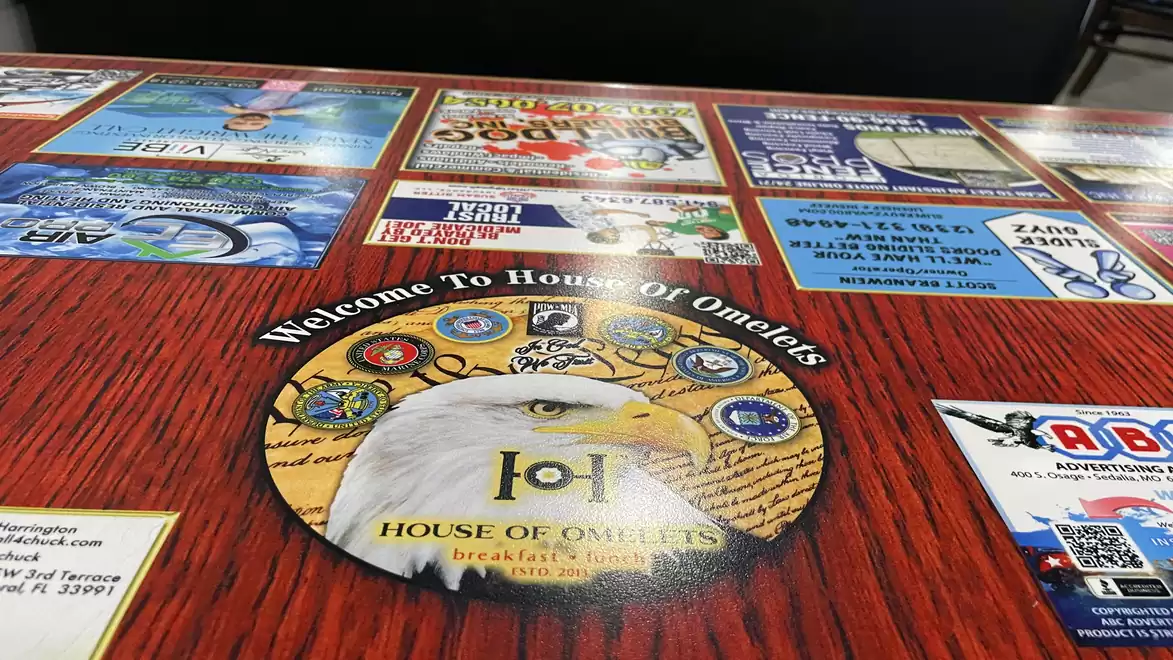 Table with various colorful brochures and a large sticker featuring an eagle and the text 