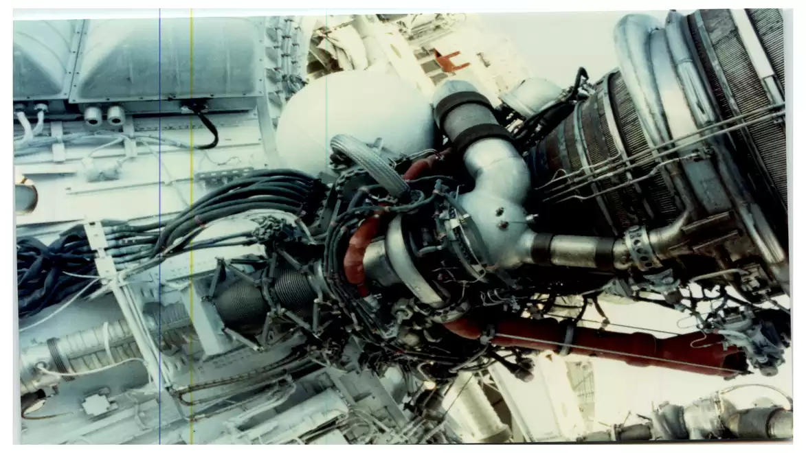 Close-up view of a complex machine structure with pipes and cables, likely part of an industrial setup or spacecraft engine.