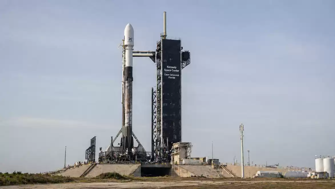A rocket is ready for launch on a launch pad against a clear sky.