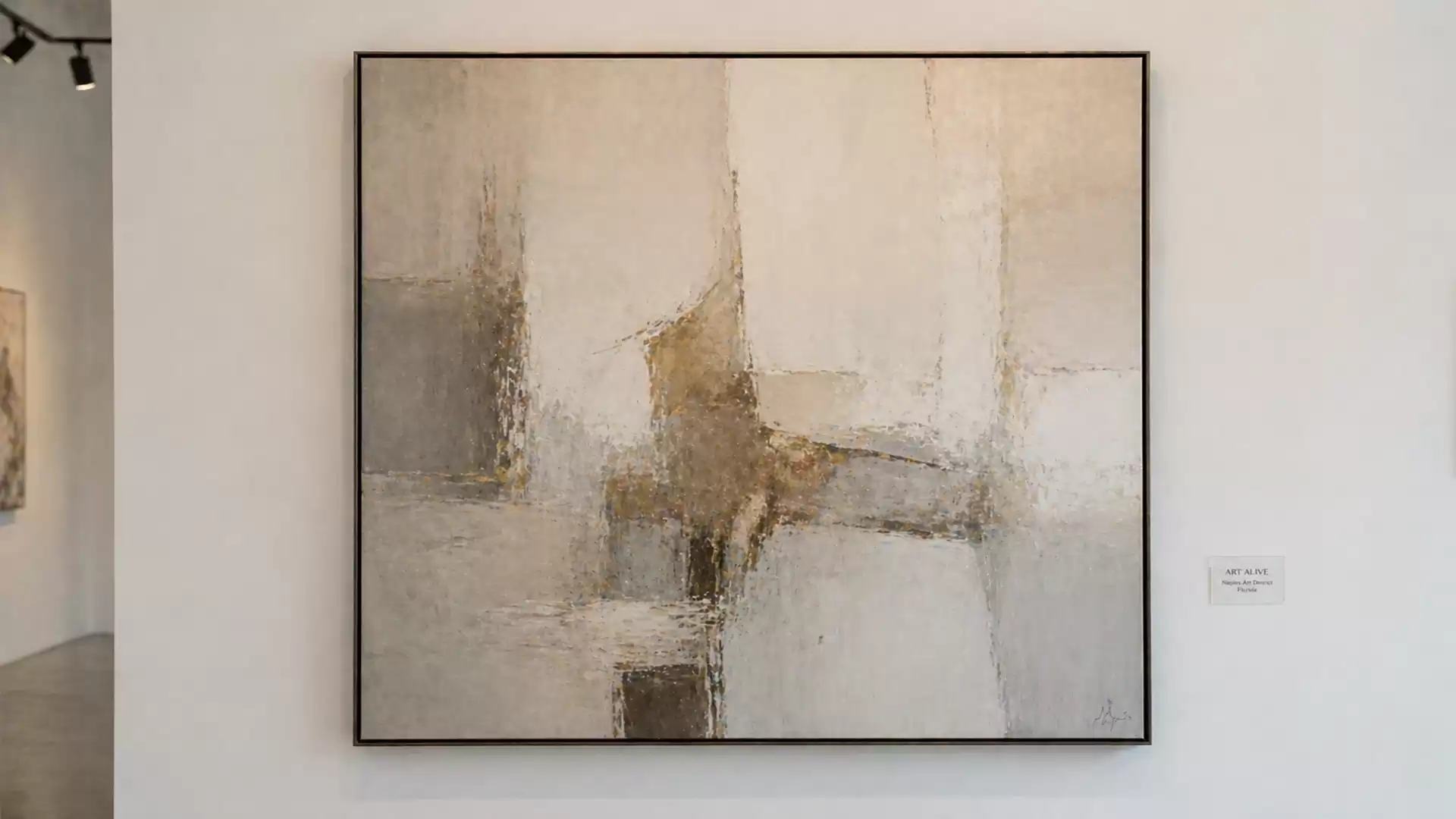 Abstract painting with light and dark color patches in a gallery room