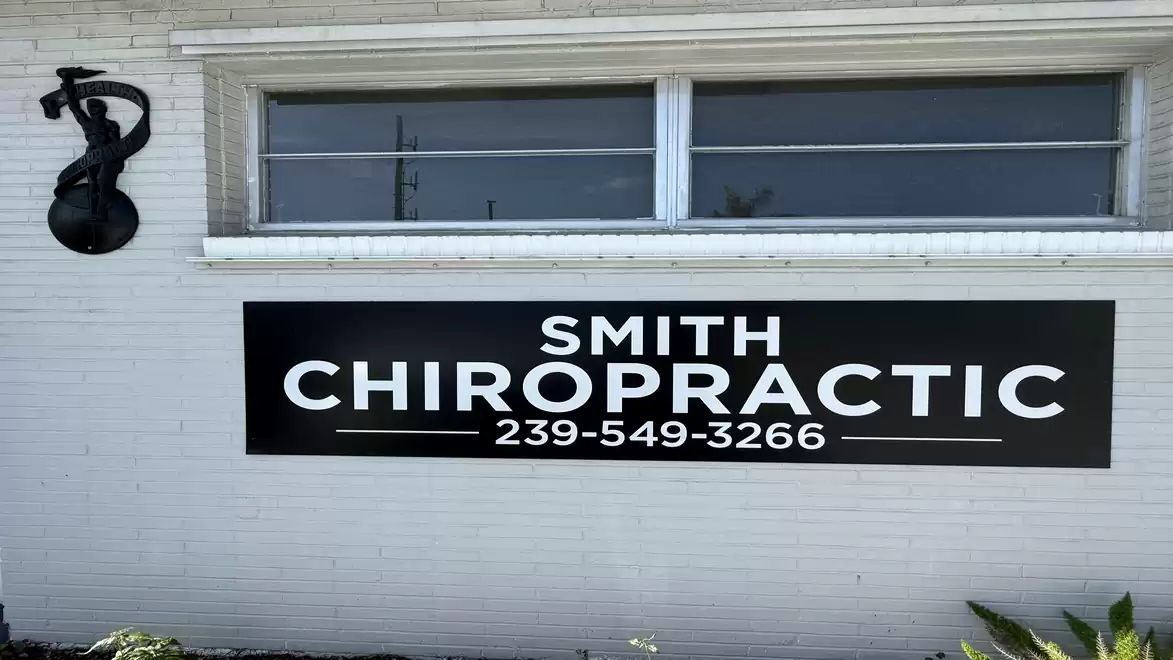 View of a building with a sign for 'Smith Chiropractic' and decorative metalwork on the wall.