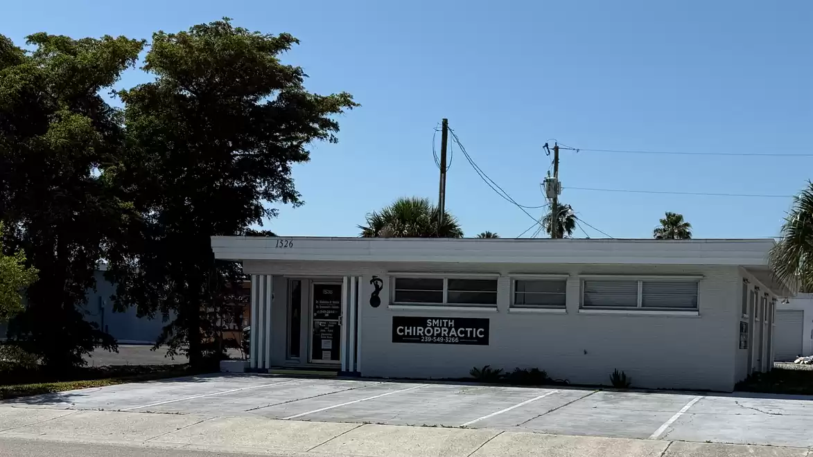 A small building with a sign reading 'Chiropractic', surrounded by trees on a sunny day.