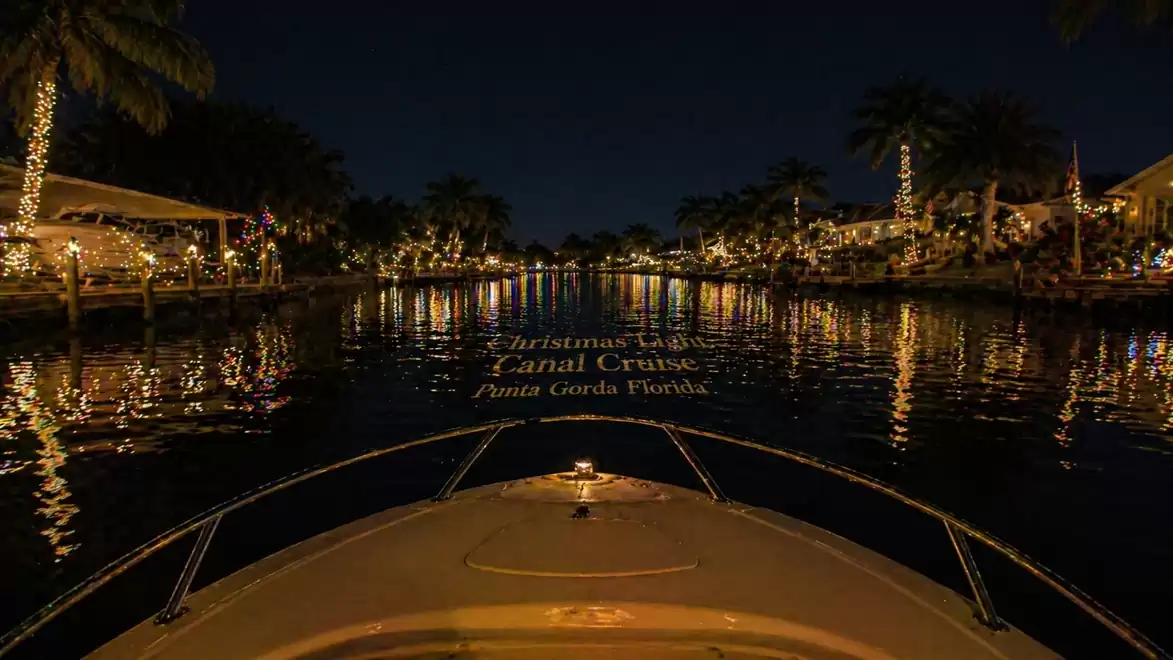 Night view of a canal with a boat and illuminated houses in Punta Gorda, Florida.