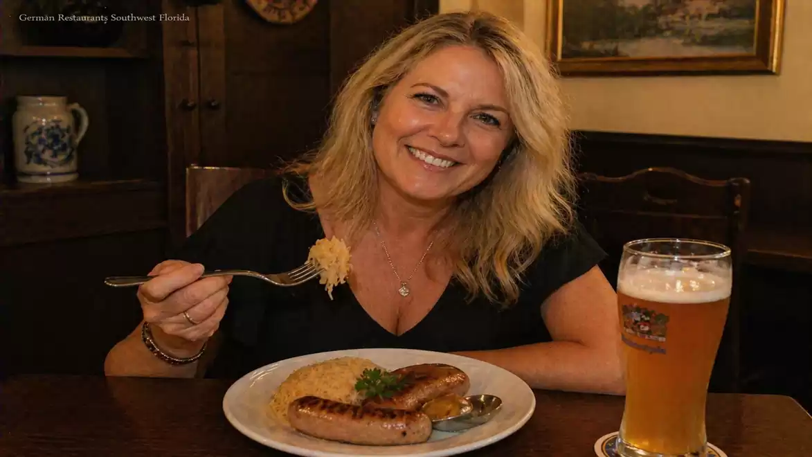 A woman in a German restaurant sits at a table enjoying a traditional German meal with sausages and sauerkraut along with a glass of beer.