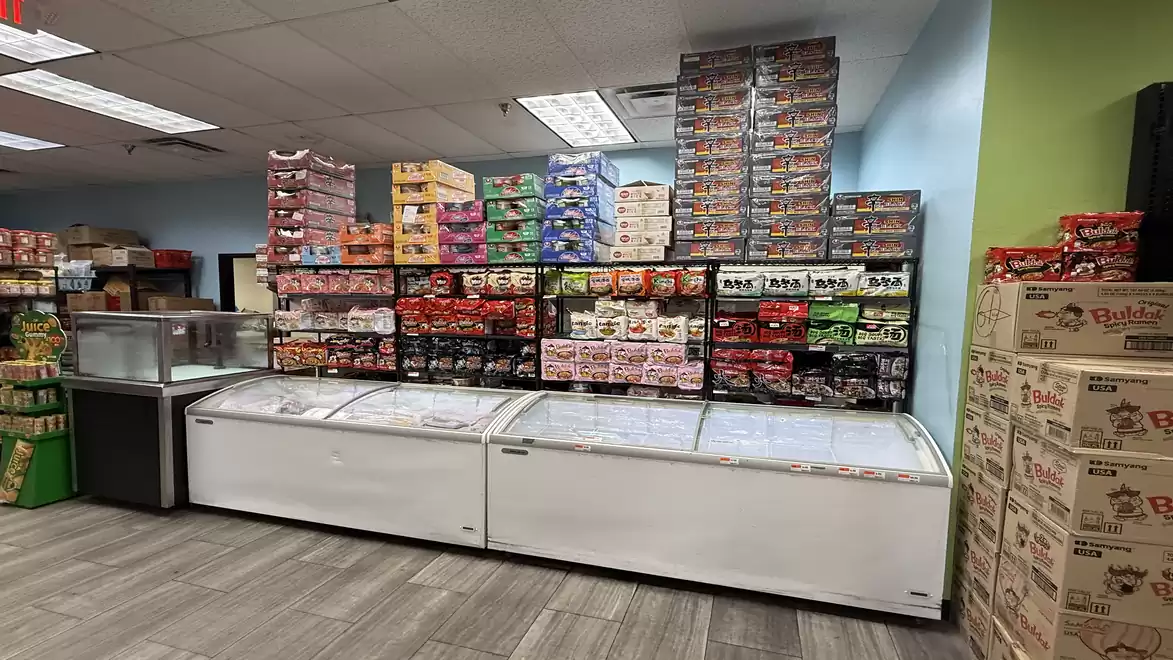Freezers in a store, surrounded by stacked food boxes.