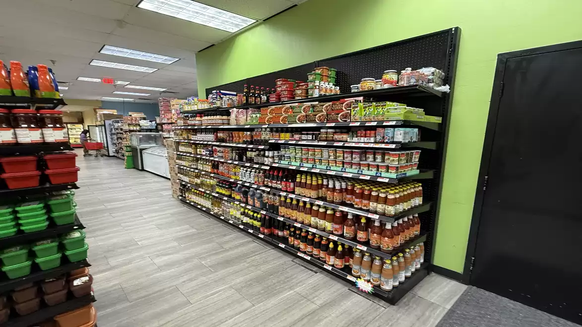 Supermarket aisle with shelves full of spices and sauces in colorful packaging.