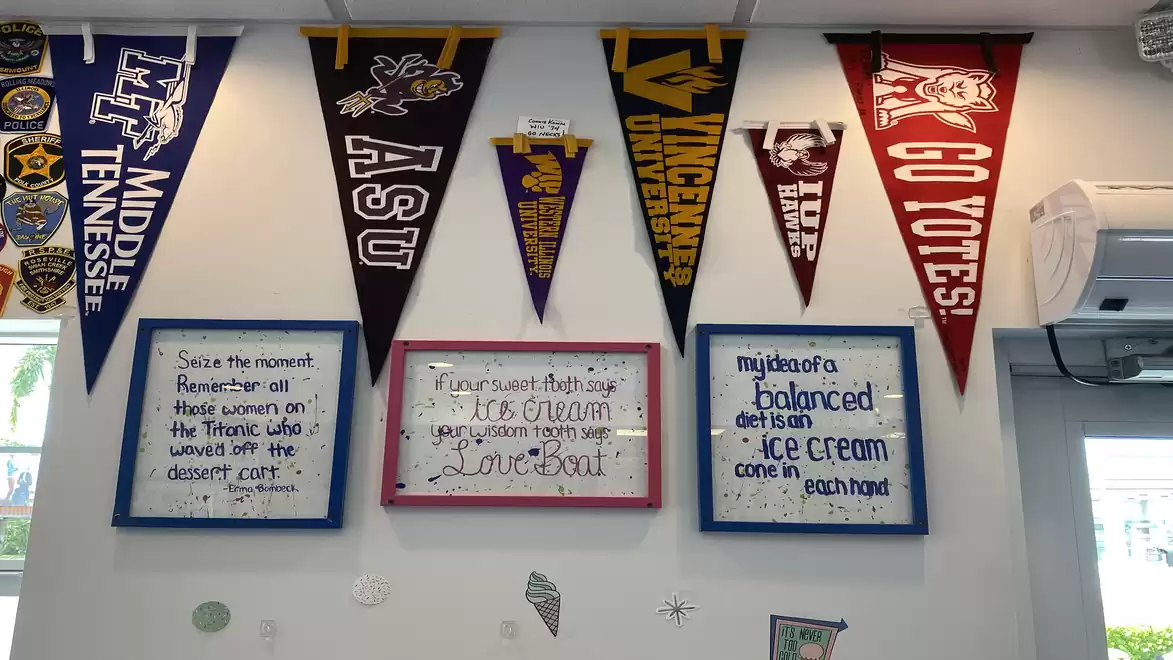 A room with various university banners on the wall and boards with handwritten quotes about ice cream.