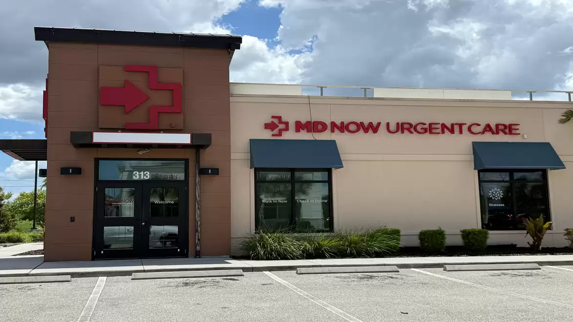 A building with the sign 'MD Now Urgent Care', blue sky and clouds in the background.
