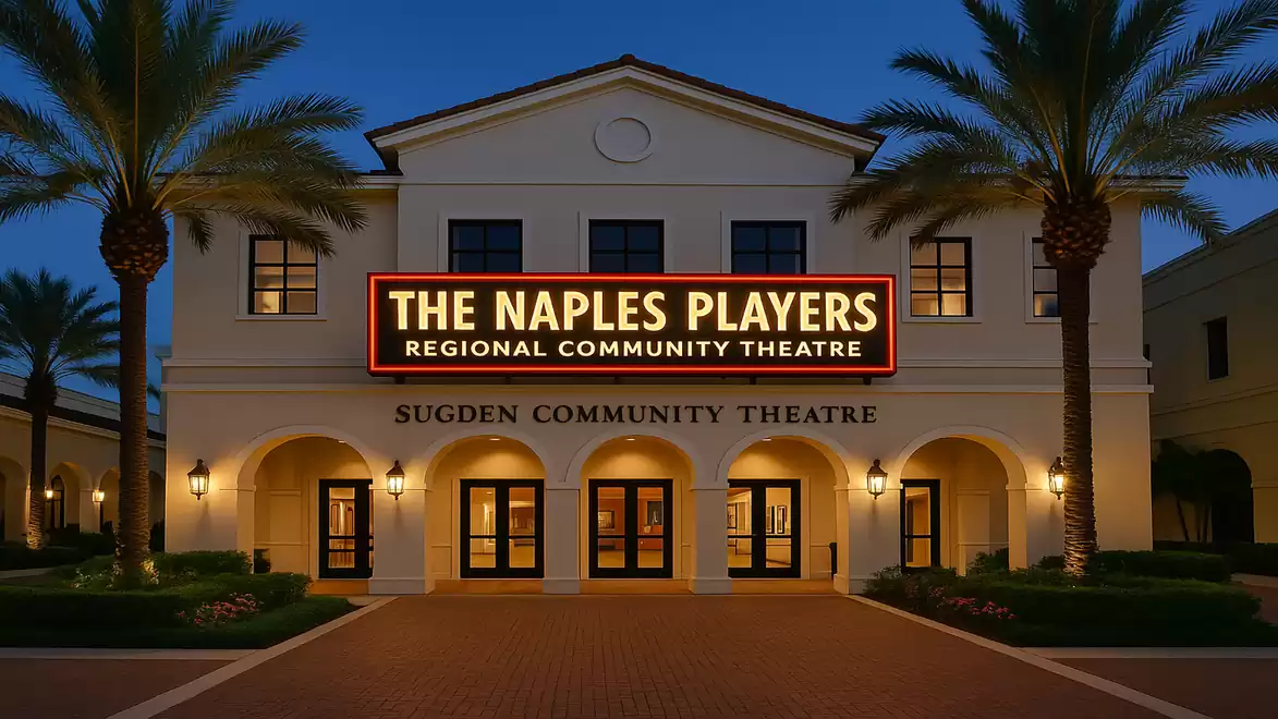 Theater building at night with illuminated signs and palm trees.