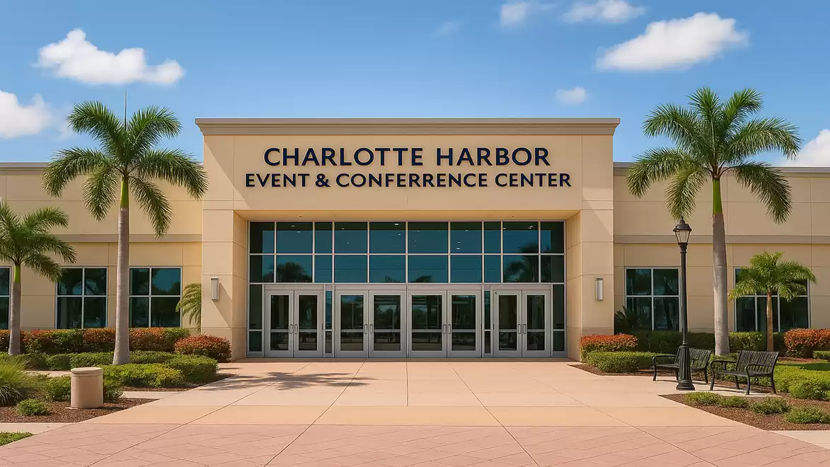 Entrance of the Charlotte Harbor Event & Conference Center with palm trees and clear sky.