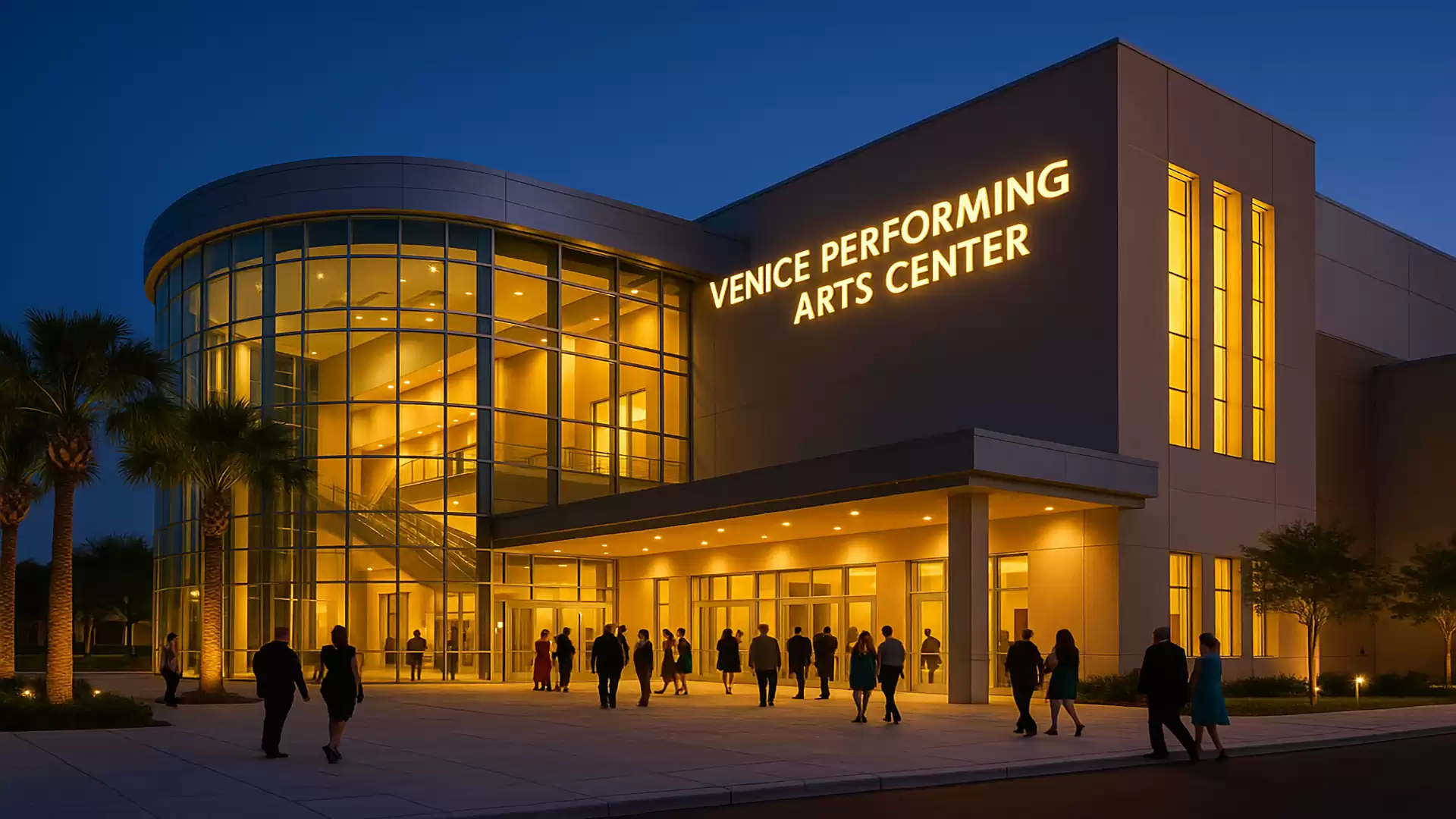 Outside view of the Venice Performing Arts Center at night with illuminated facade and people entering and exiting.