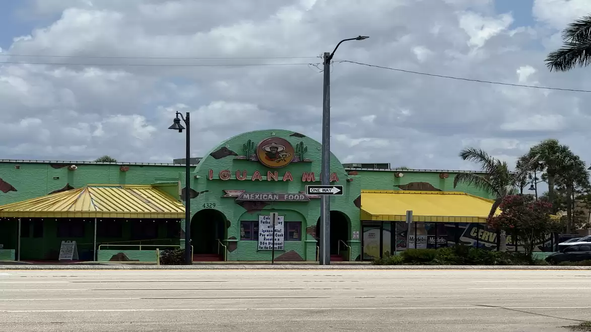 Colorfully painted Mexican restaurant with a yellow awning and a central clock on the facade.