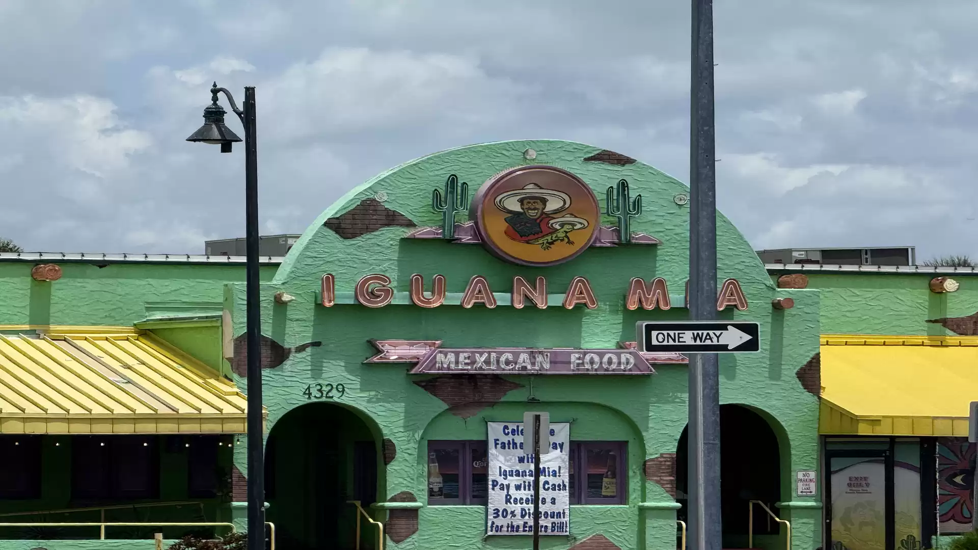 Image of a green Mexican restaurant with a yellow roof and 'Iguana Mia' sign.