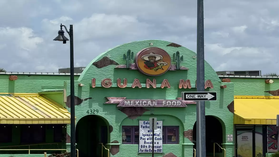Image of a green Mexican restaurant with a yellow roof and 'Iguana Mia' sign.