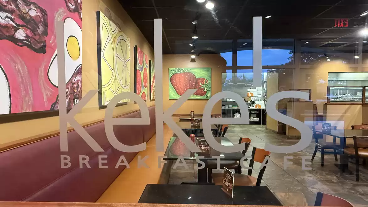 A cozy breakfast café with colorful paintings on the walls, comfortable seating areas, and a warm atmosphere.