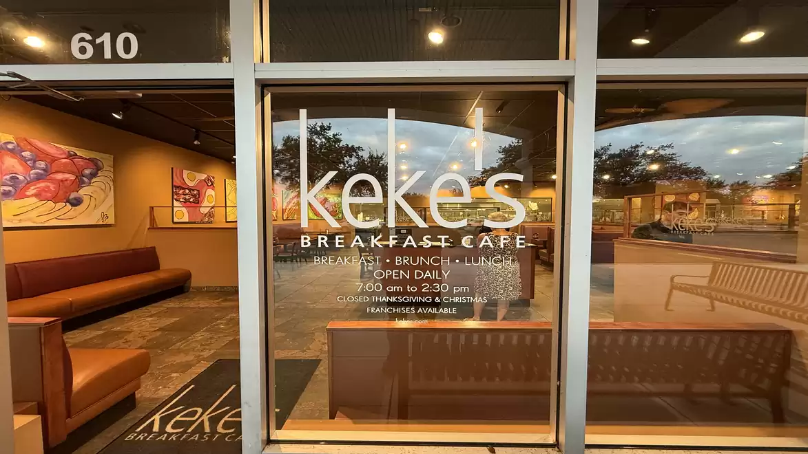 Entrance of a café with the sign 'Keke's Breakfast Cafe', showing both interior and exterior areas.