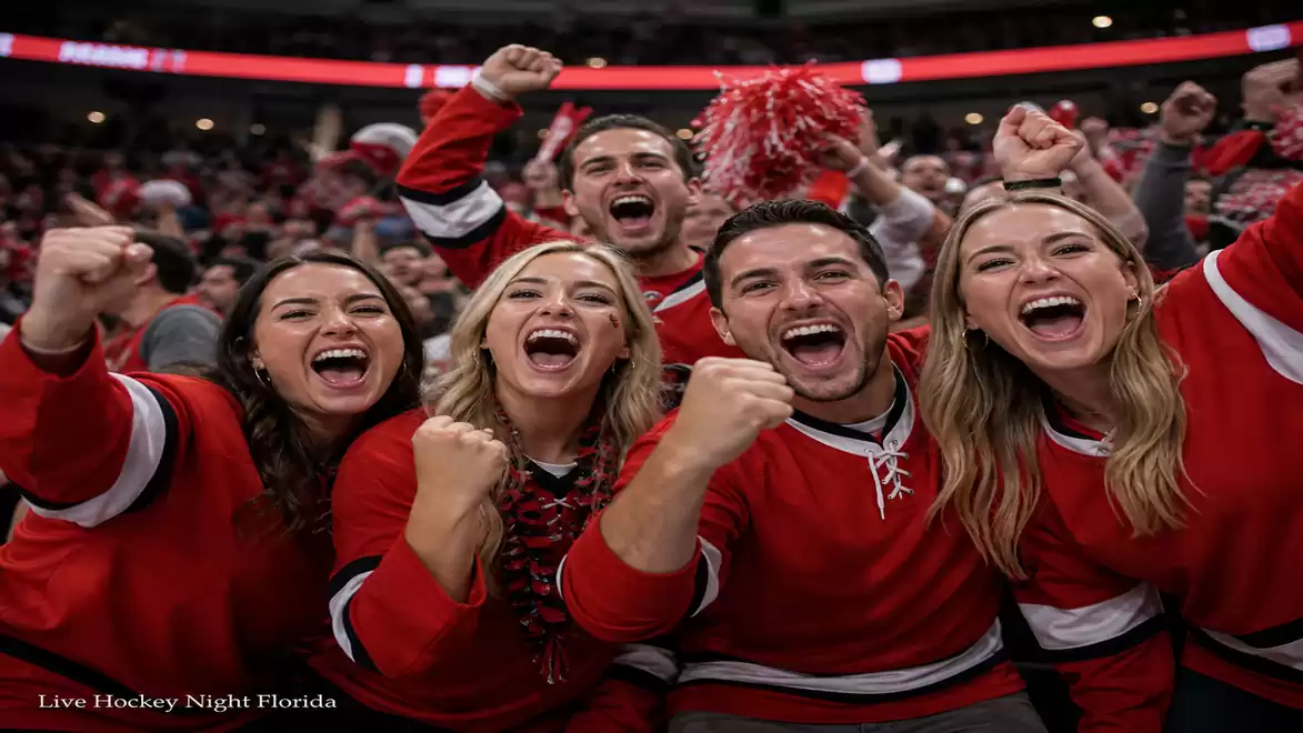 A group of five cheering hockey fans wearing red clothes celebrate during a game in an arena.