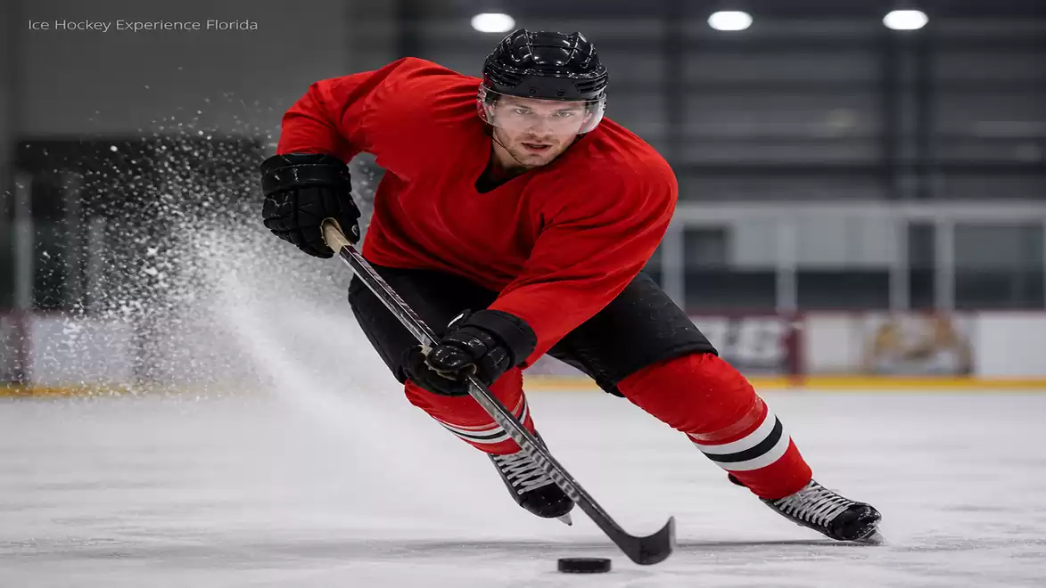 Ice hockey player in red jersey shooting the puck on ice.