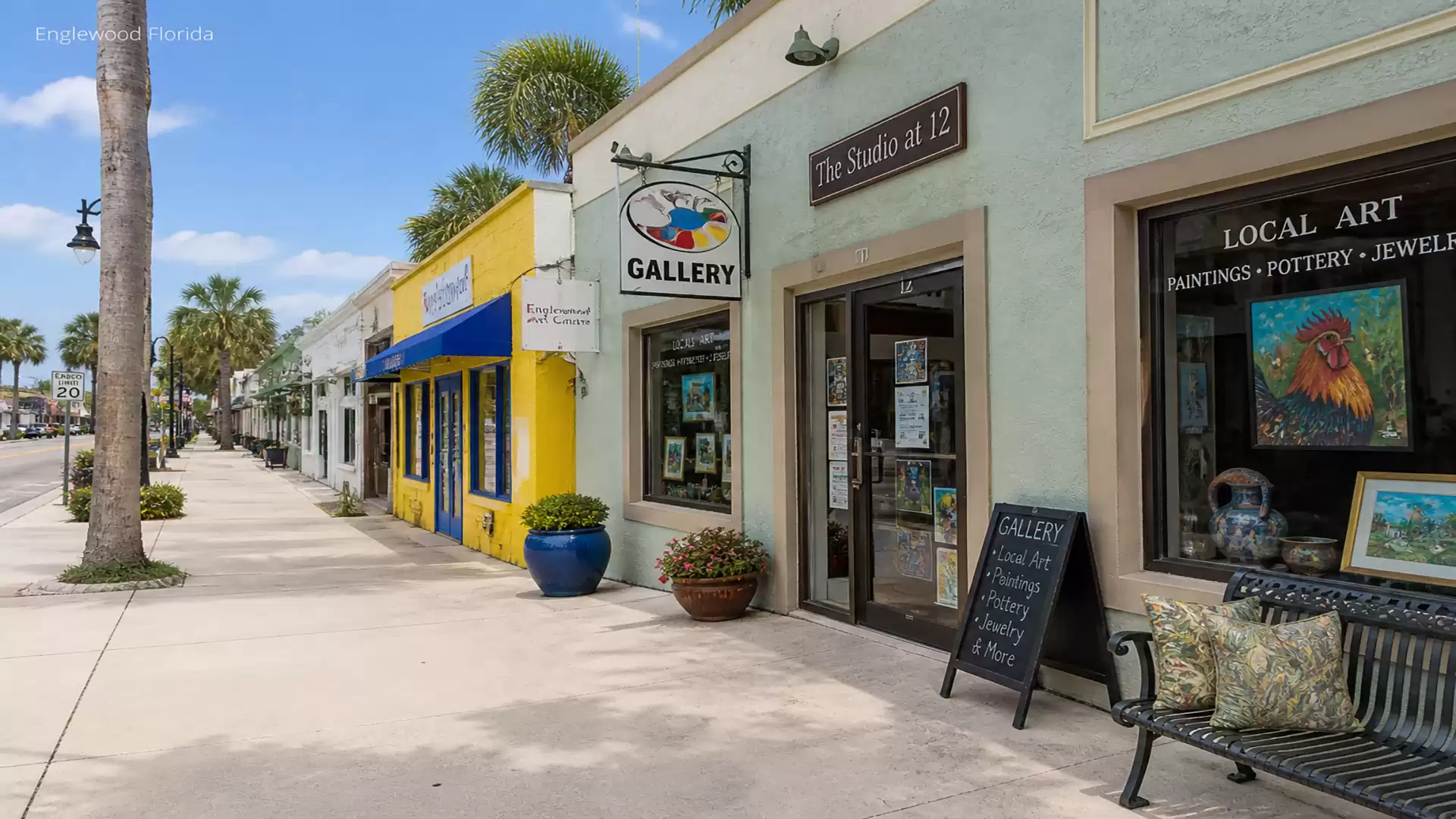 A charming shopping street with art galleries and colorful stores on a sunny day.