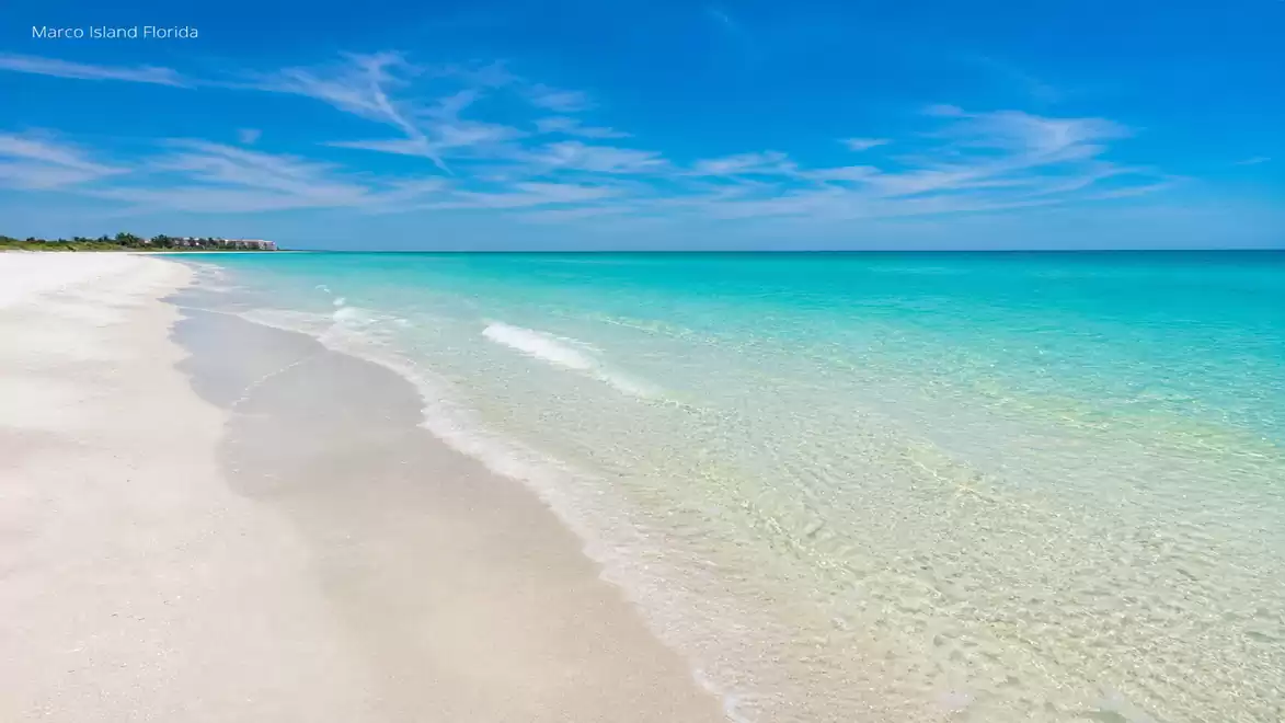 A beautiful beach at Marco Island, Florida with clear water and blue sky.