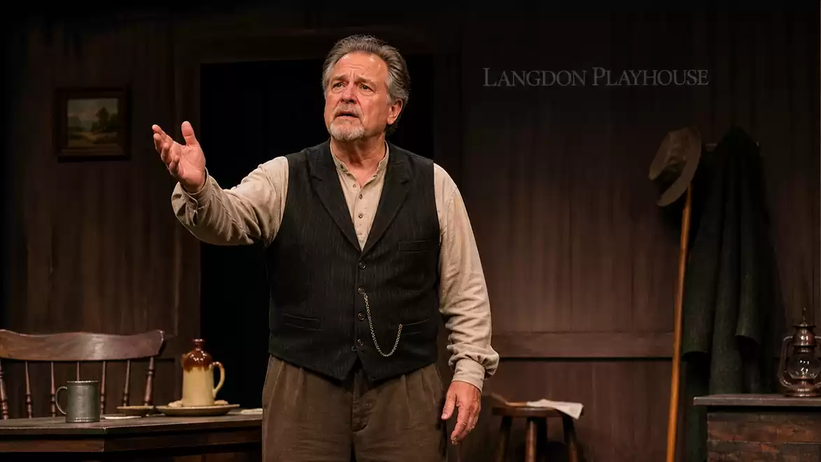 Male actor in a theater scene at the Langdon Playhouse on stage, wearing a vintage outfit.