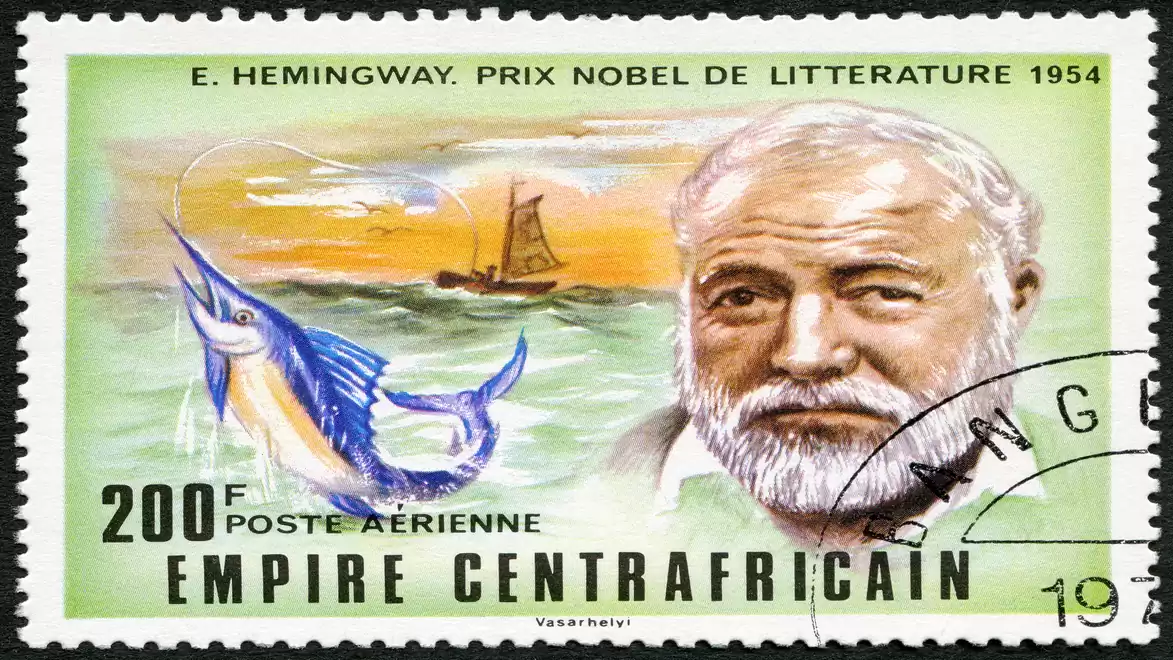 Postage stamp with a portrait of Ernest Hemingway, a 200 F denomination, and a blue marlin in the sea.