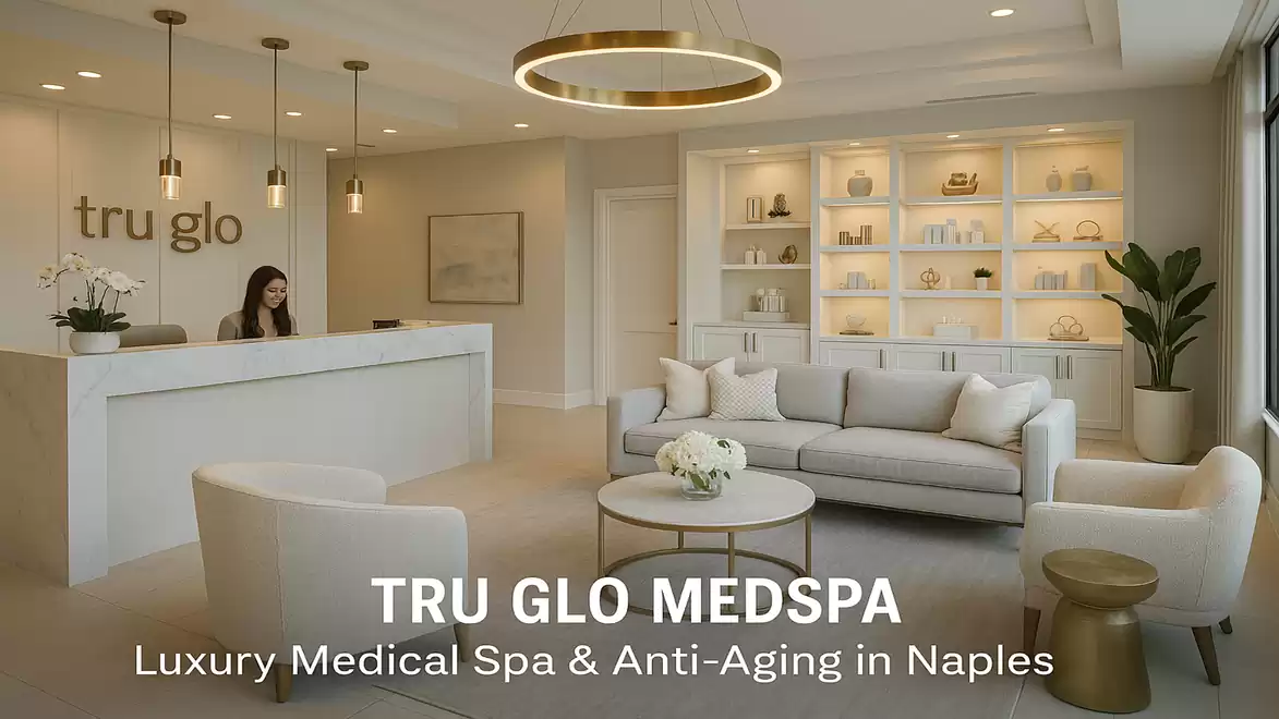 Interior view of a luxury medical spa with a reception area, seating, and decorative shelves. A person is standing behind the reception.
