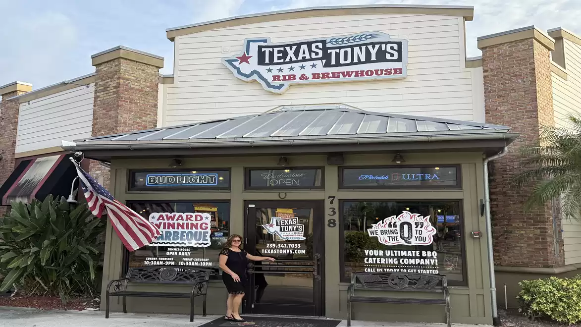 Exterior view of Texas Tony's Rib & Brewhouse with US flag and awards in the window.