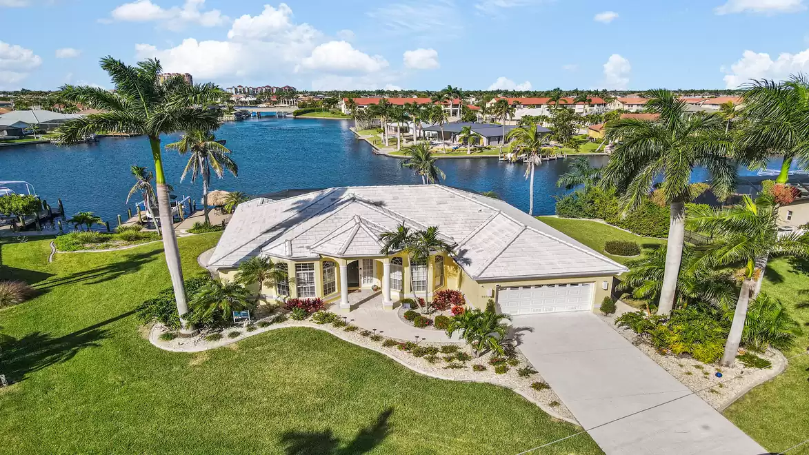 Aerial view of the luxurious residential home Villa Rosegarden in a tropical setting with palm trees and water view.