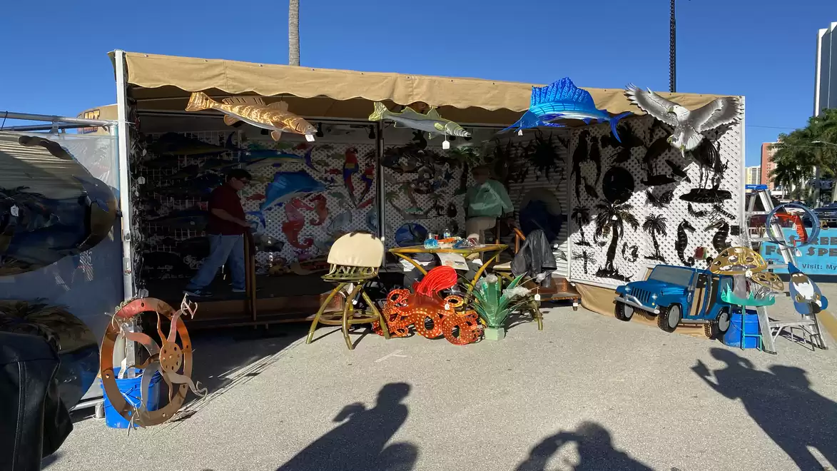 A colorful market stall with various decorative items and toys under a fabric roof.