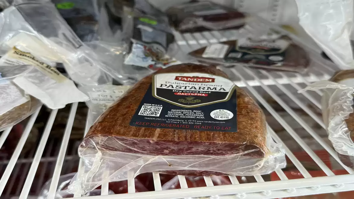 A refrigerator shelf with packaged cured beef and various other products.