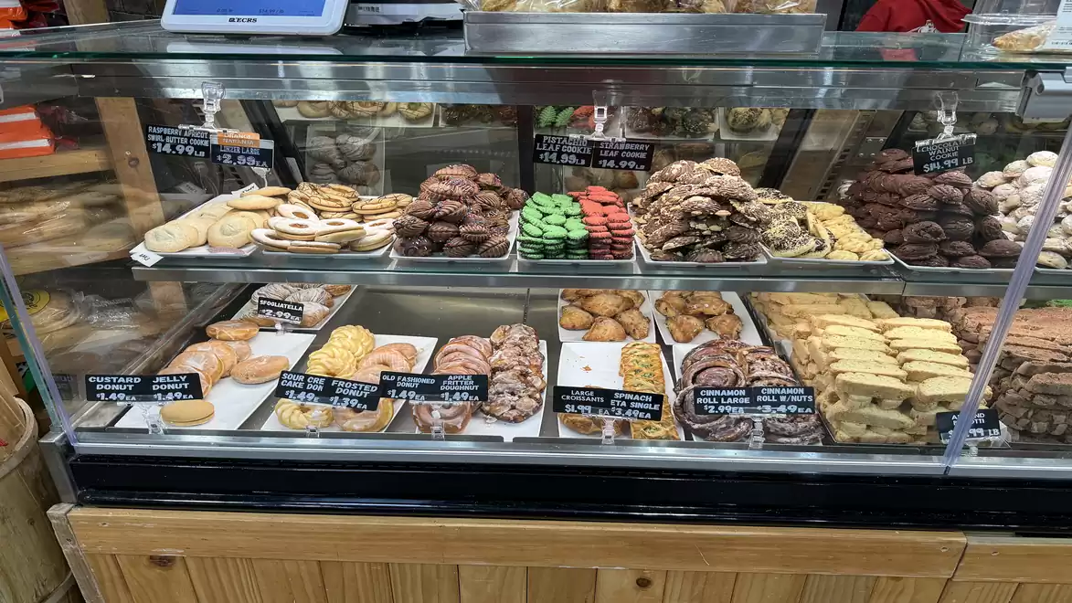 A bakery display case showing a variety of pastries such as cookies, cakes, and baked goods.