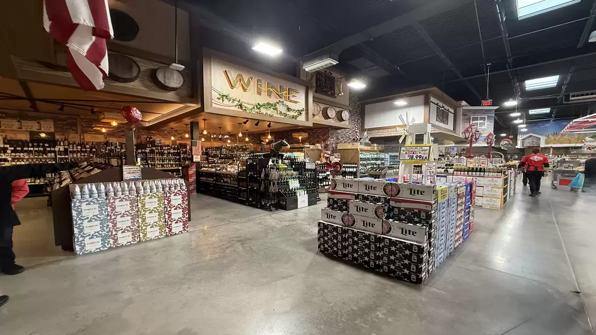Interior of a large supermarket with various beverage and wine sections.
