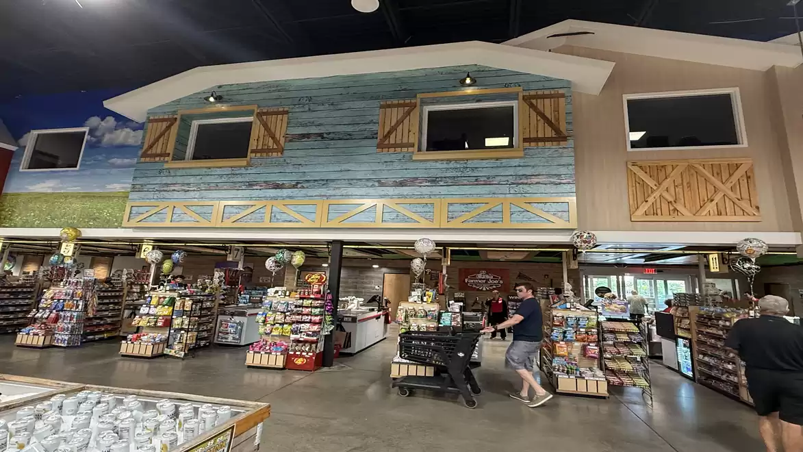 Interior view of a supermarket with a rustic facade and customers shopping.