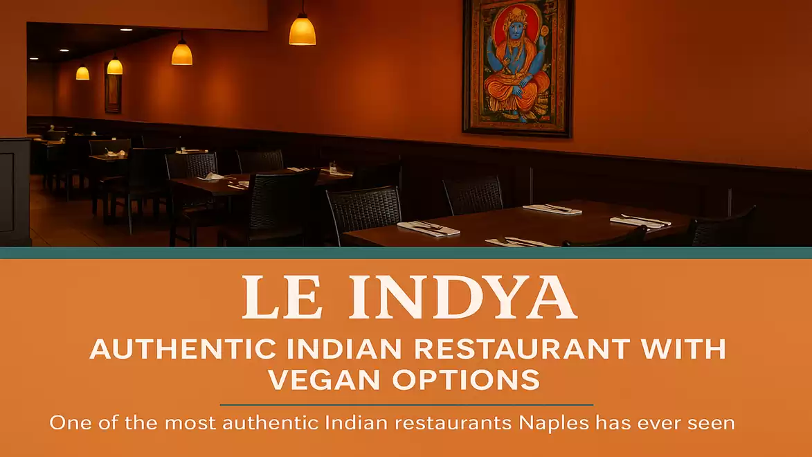 Interior view of an authentic Indian restaurant with vegan options. The warm orange tones and Indian art create an inviting atmosphere.