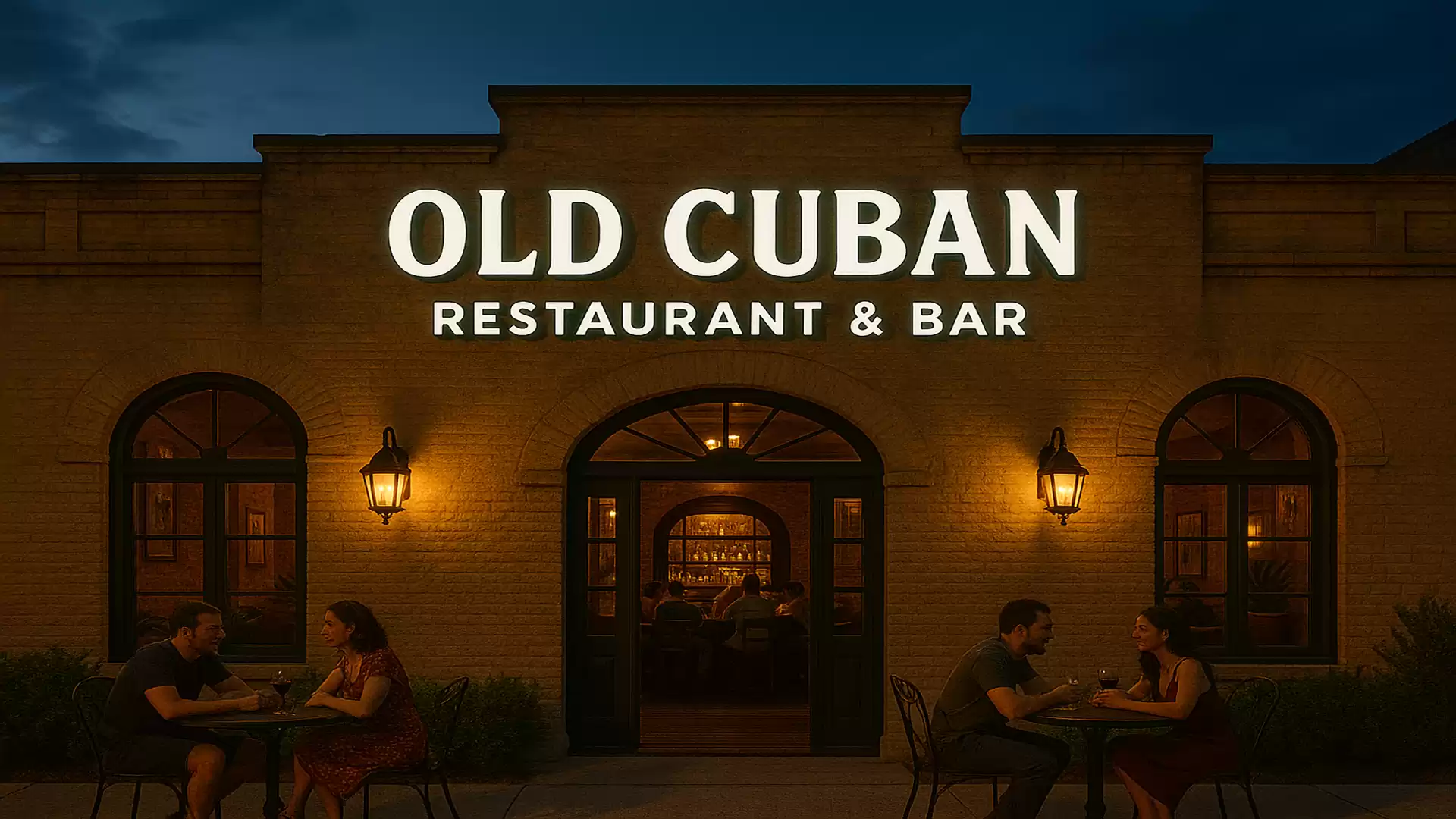 Exterior view of Old Cuban Restaurant & Bar at night with people sitting outside at tables.