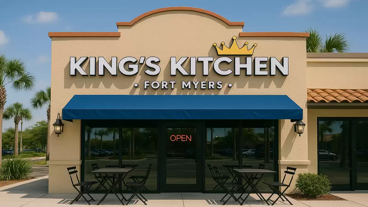 Front view of a restaurant named King's Kitchen in Fort Myers, with a blue awning and tables in front.